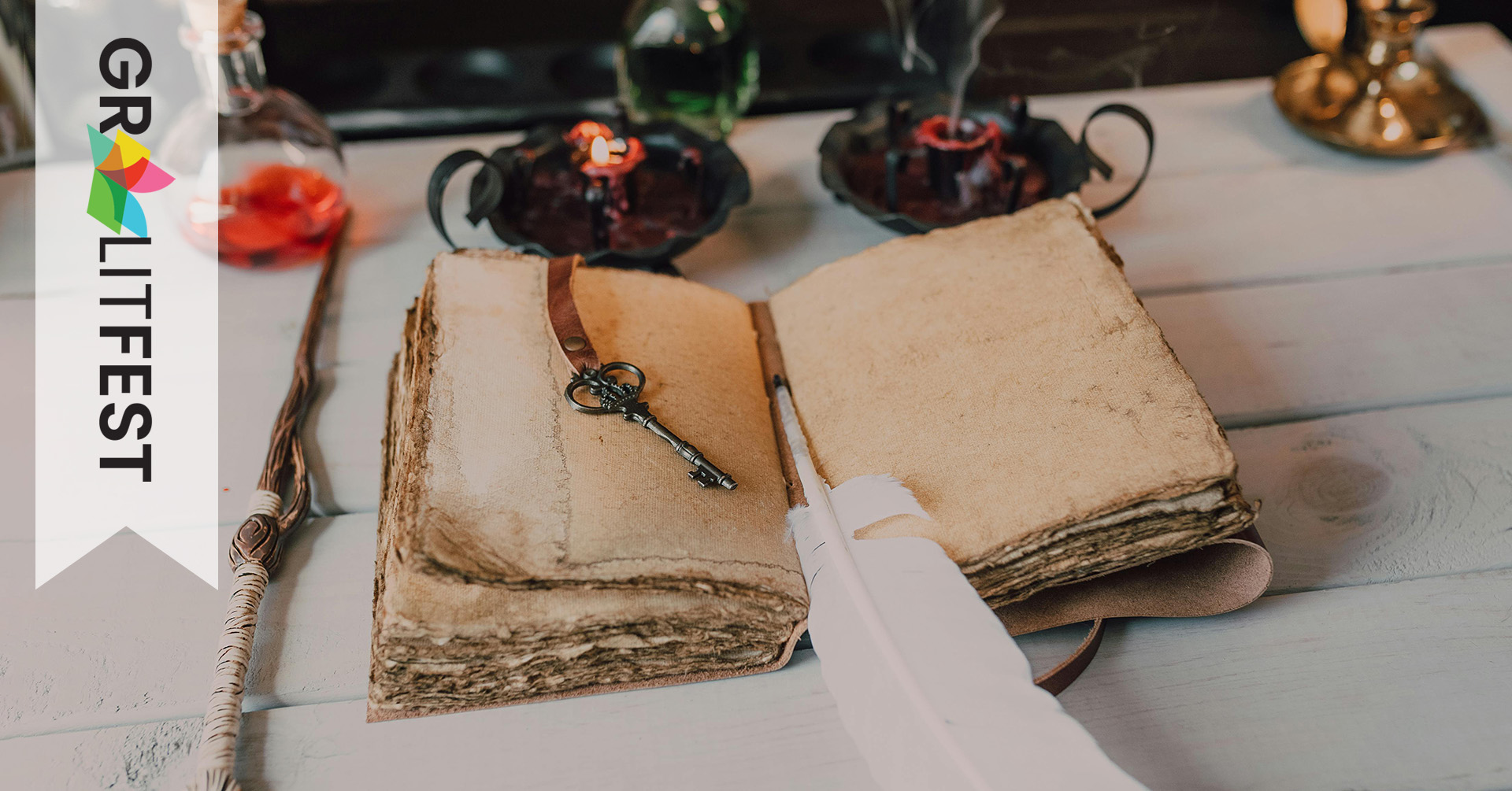 quill and key on parchment book with candles, wand, and potion bottle