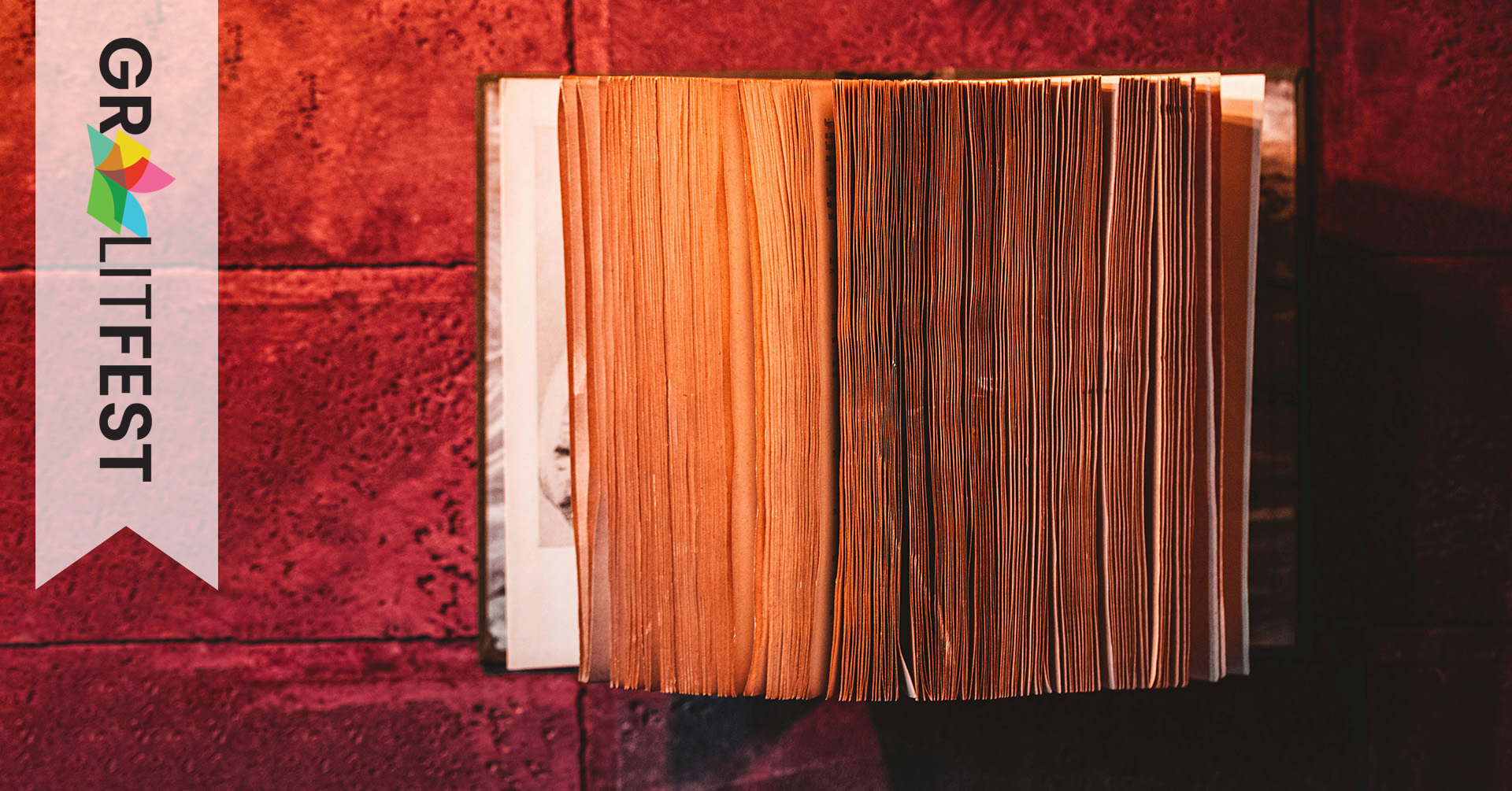 dirty book open on red brick wall