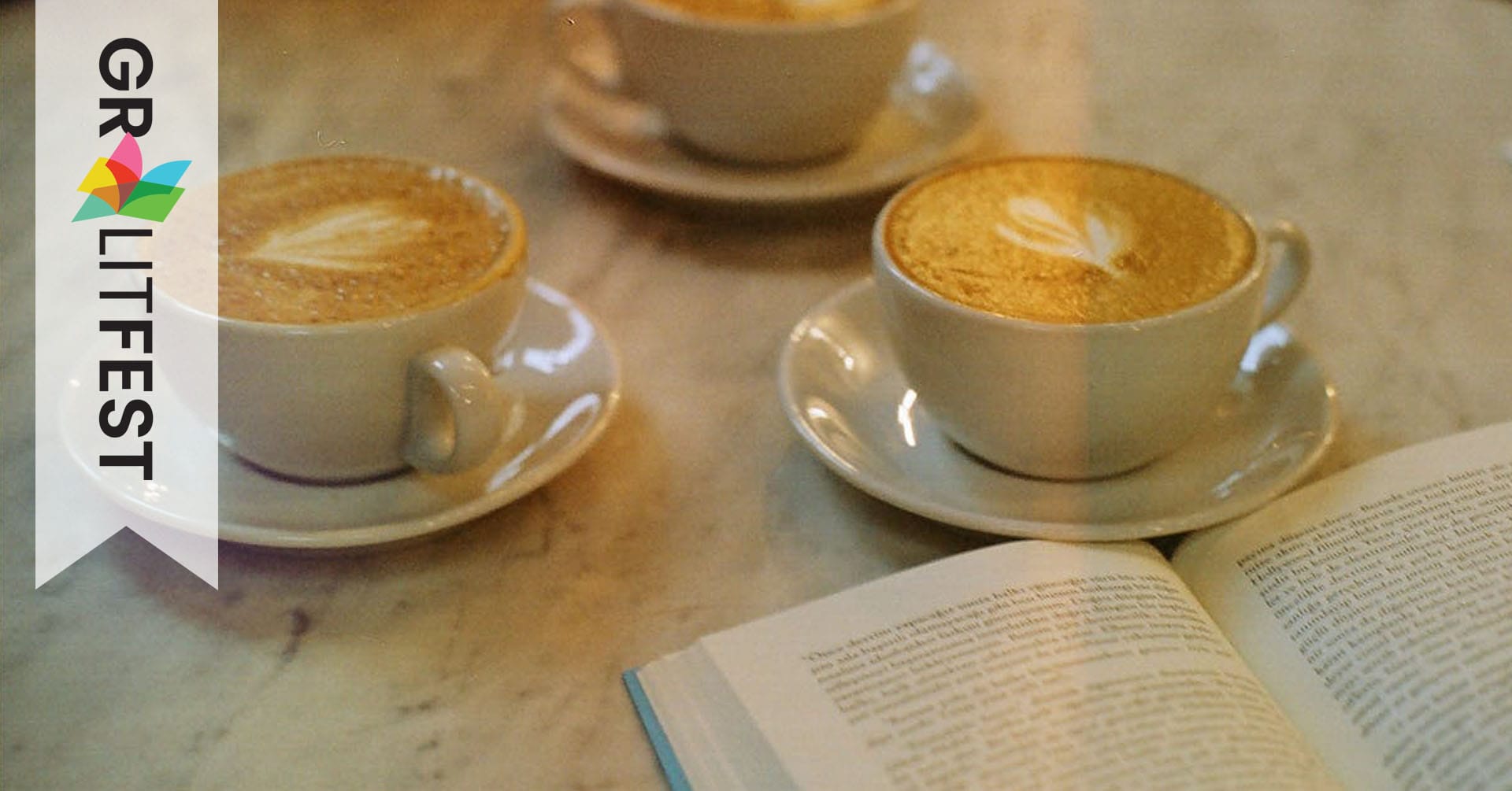 three cappuccinos and a book on a cafe table